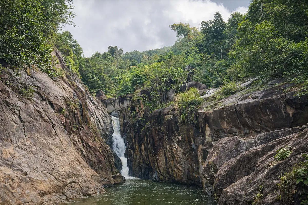 Hidden waterfall dropping into natural pool at Charco El Hippie in Naguabo Puerto Rico