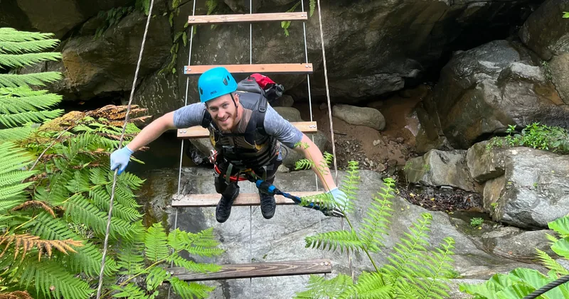 Guest crossing a via ferrata suspension bridge over the river, El Yunque, Puerto Rico