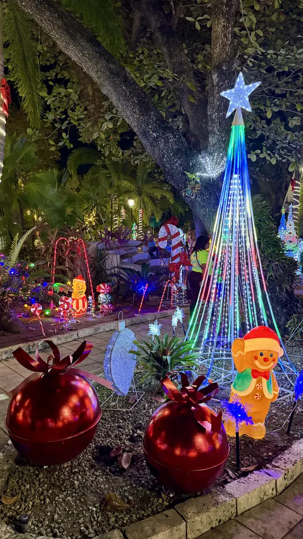 Holiday light garden with a glowing tree, a gingerbread figure and giant red ornaments in Puerto Rico